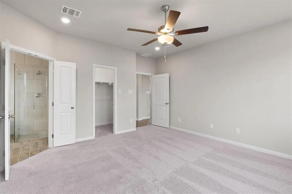 332 Stellar Wind Drive Georgetown, TX 78628 - Photo 14 of 29 A comfortable bedroom with soft carpet flooring provides direct access to a well-appointed bathroom and a spacious walk-in closet.