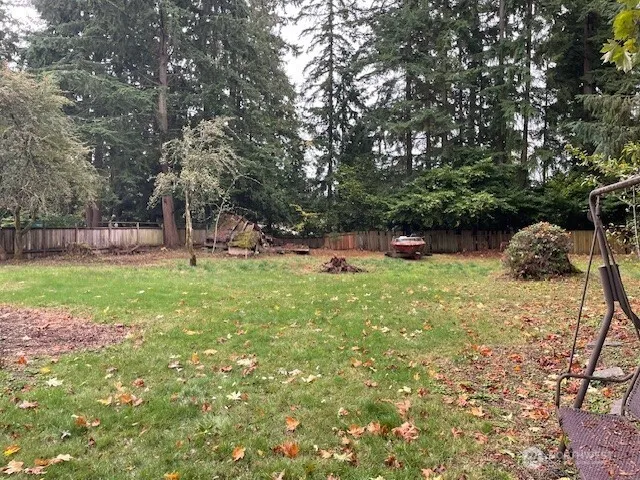 a view of a backyard with a garden and fire pit