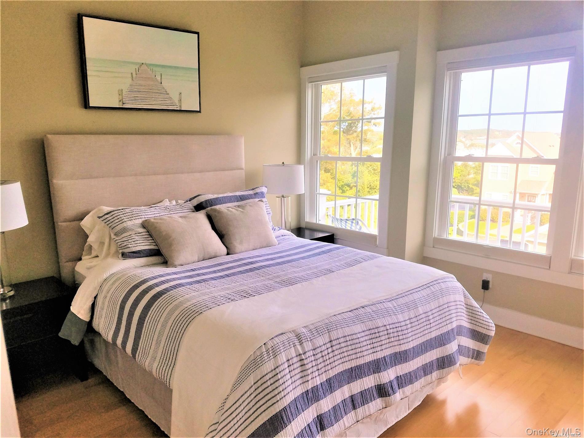 20 Canoe Place Road, Unit 8 Hampton Bays, NY 11946 - Photo 9 of 18 a bedroom with a bed and a window