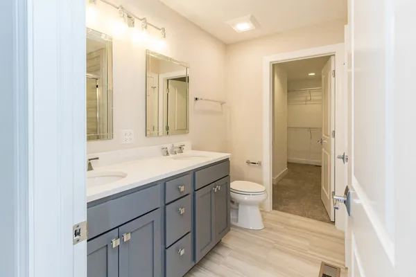 a bathroom with a double vanity sink a toilet and a mirror
