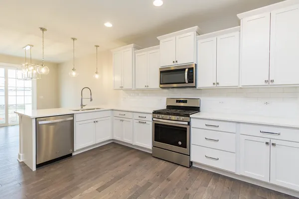a kitchen with granite countertop white cabinets and stainless steel appliances