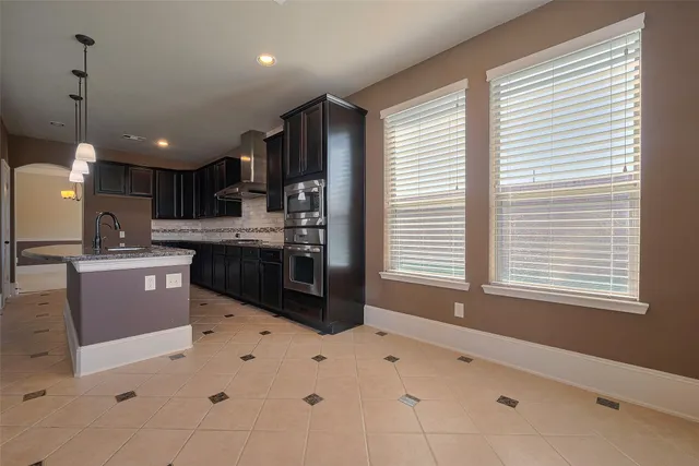 a kitchen with stainless steel appliances kitchen island granite countertop a sink and a stove