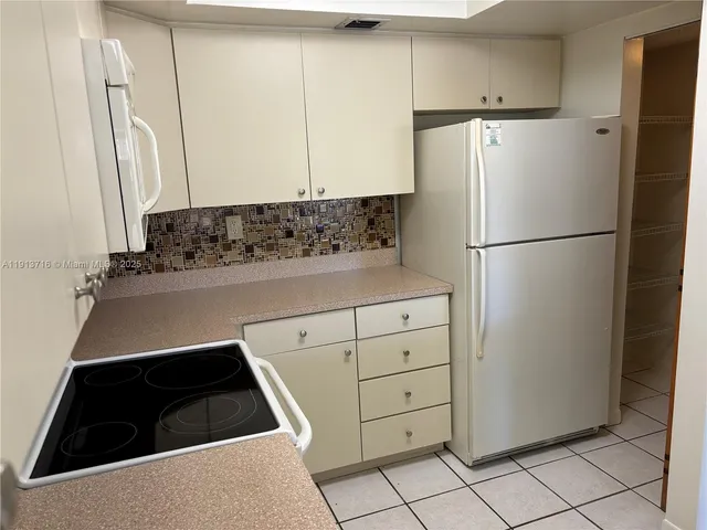 a kitchen with a refrigerator and a sink