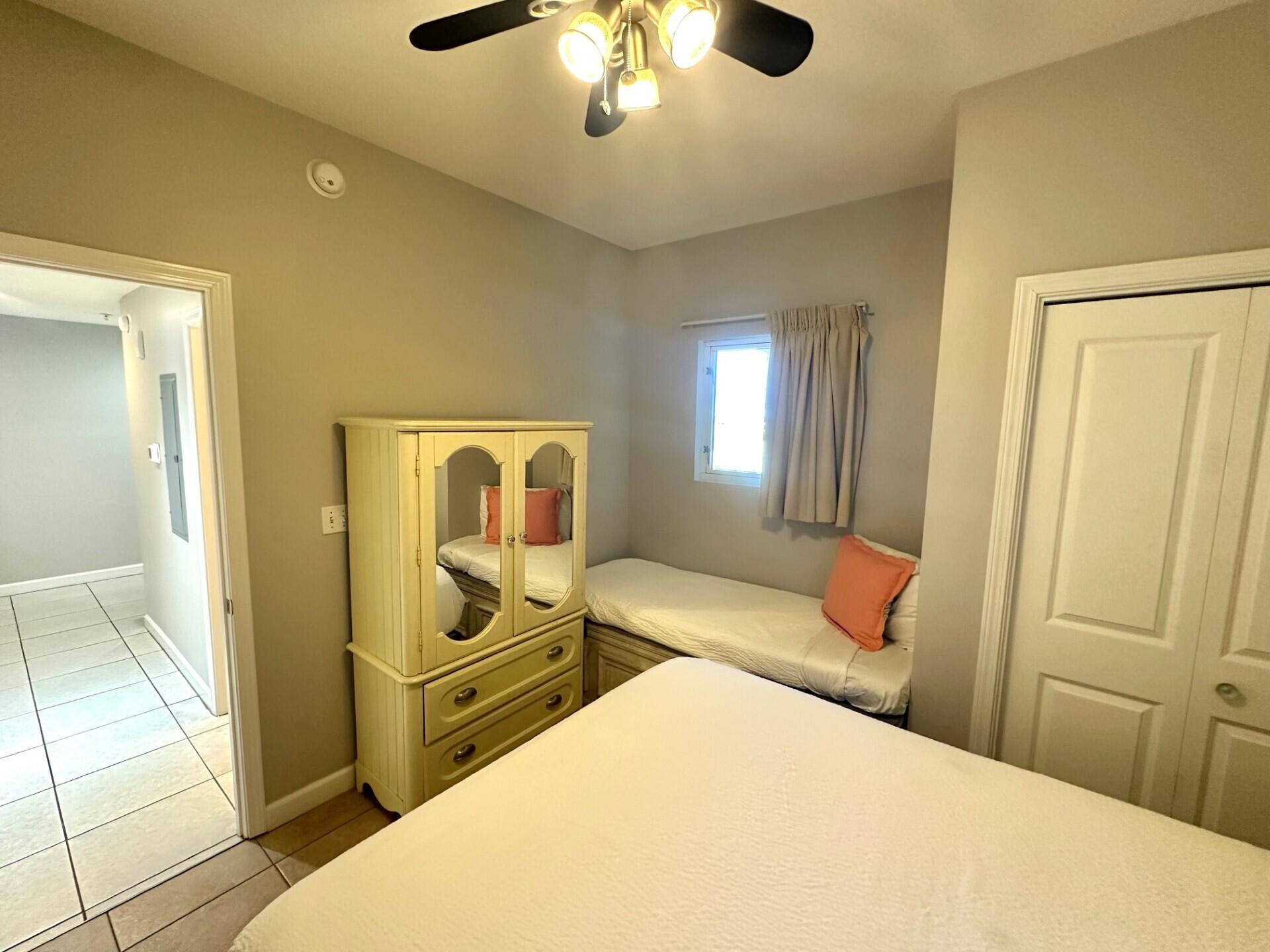 12011 Front Beach Road, Unit 103B Panama City Beach, FL 32407 - Photo 15 of 38 a bedroom with a bed and a chandelier