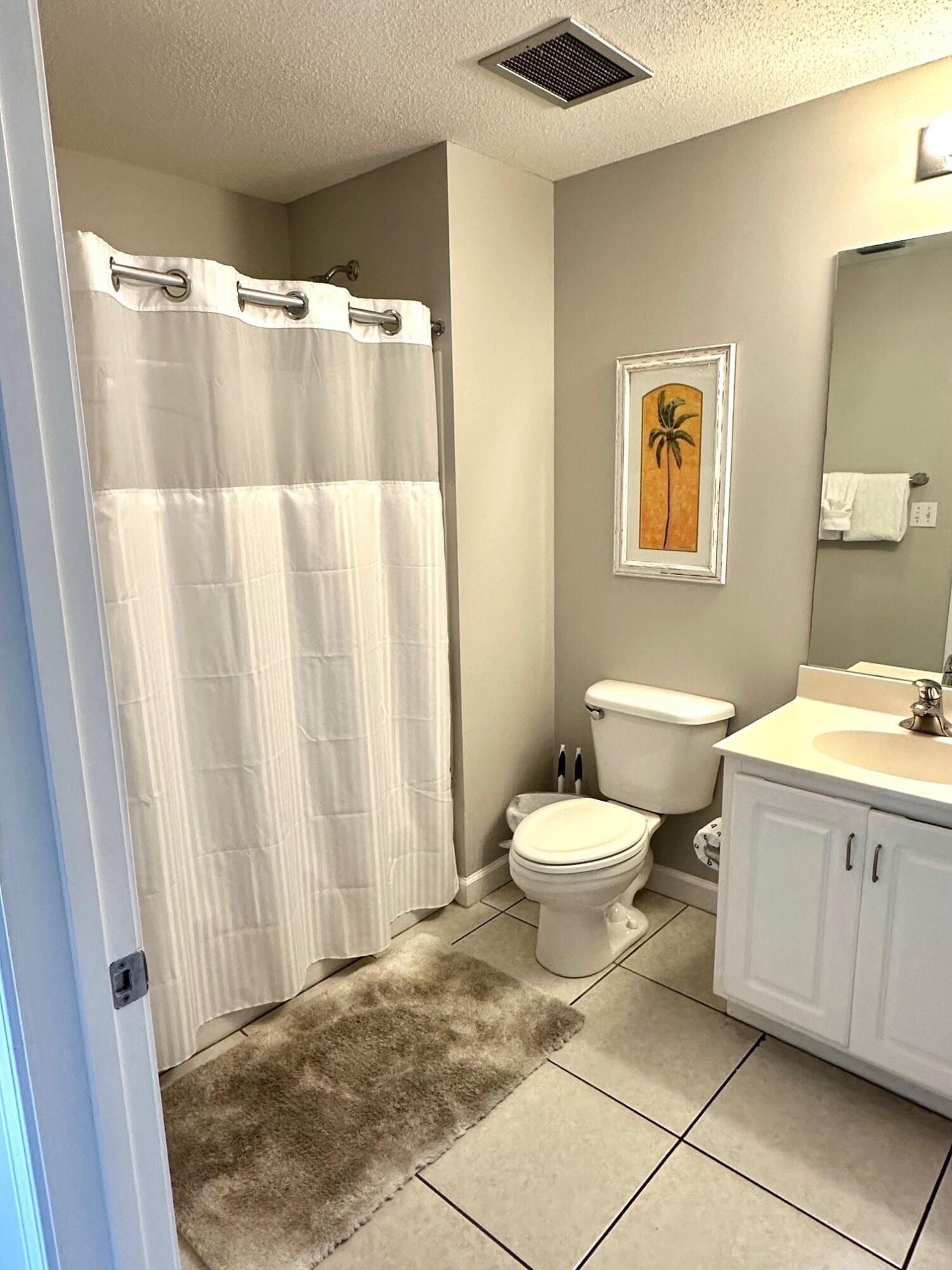 12011 Front Beach Road, Unit 103B Panama City Beach, FL 32407 - Photo 16 of 38 a bathroom with a toilet sink and shower