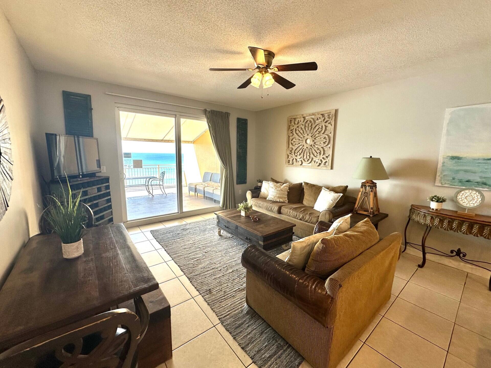 12011 Front Beach Road, Unit 103B Panama City Beach, FL 32407 - Photo 2 of 38 a living room with furniture fireplace and a large window
