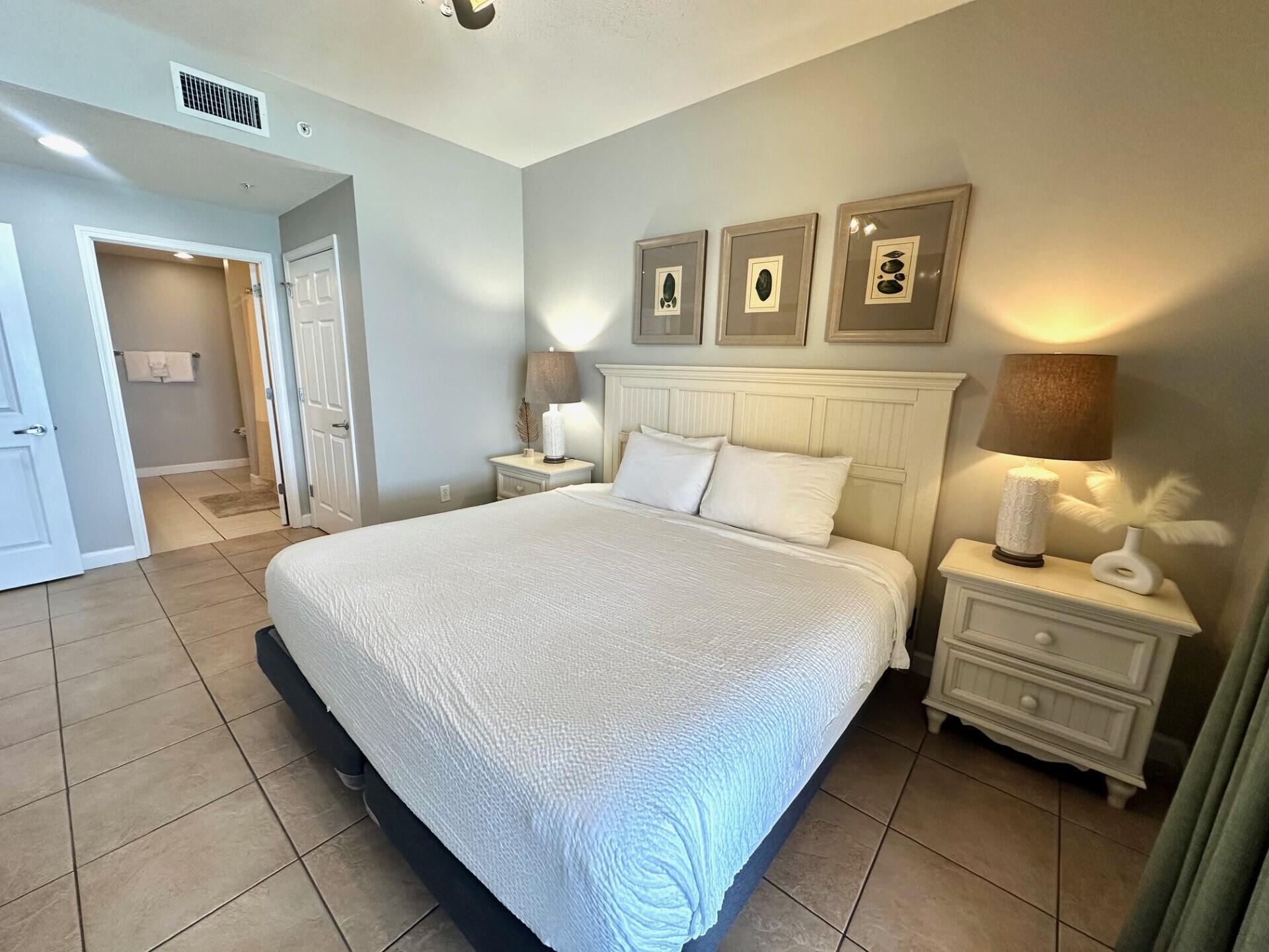 12011 Front Beach Road, Unit 103B Panama City Beach, FL 32407 - Photo 8 of 38 a bedroom with a bed and painting on the wall