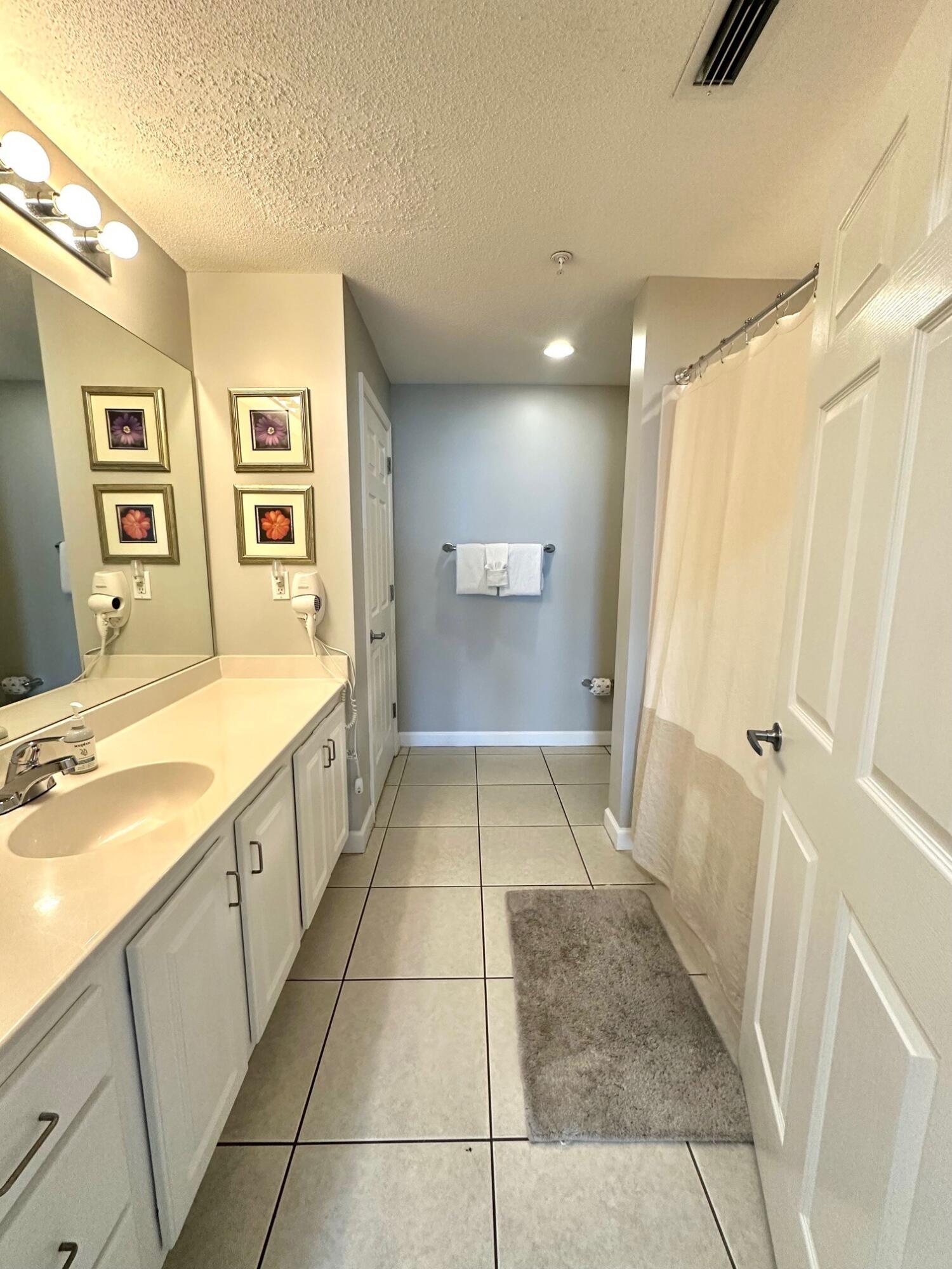 12011 Front Beach Road, Unit 103B Panama City Beach, FL 32407 - Photo 10 of 38 a bathroom with a tub sink and shower