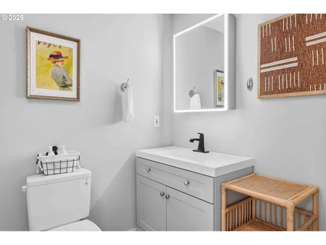 a bathroom with a sink a mirror and painting on the wall