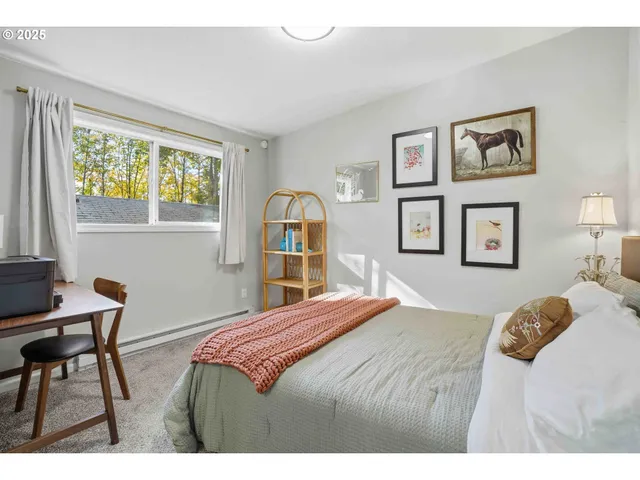 a bedroom with a bed and a table in it with window