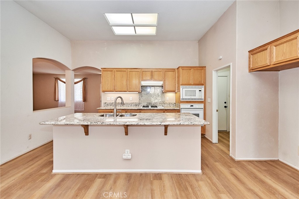 a kitchen with kitchen island a sink a stove a refrigerator and island