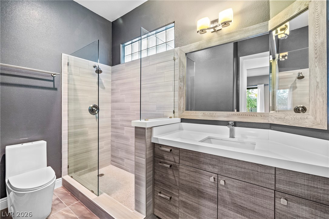 2000 Grouse Street Las Vegas, NV 89134 - Photo 14 of 89 A well-appointed bath features a spacious glass-enclosed shower and a vanity with ample storage.