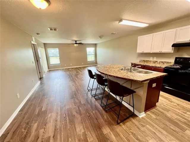 a kitchen with a table chairs and wooden floor