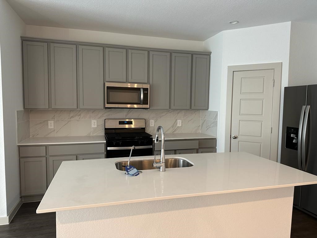 7815 Elm Birch Lane Rosharon, TX 77583 - Photo 9 of 19 a kitchen with a sink a stove and refrigerator