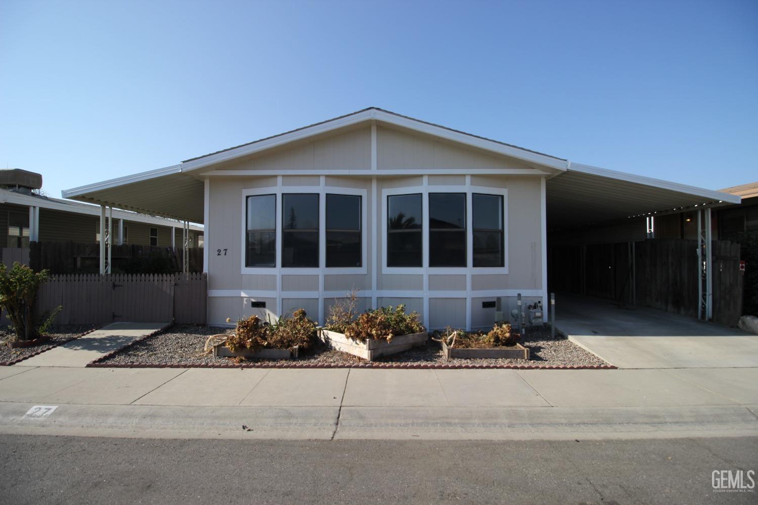 Undisclosed Address Bakersfield, CA 93307 - Photo 1 of 18 a front view of a house with a yard and garage