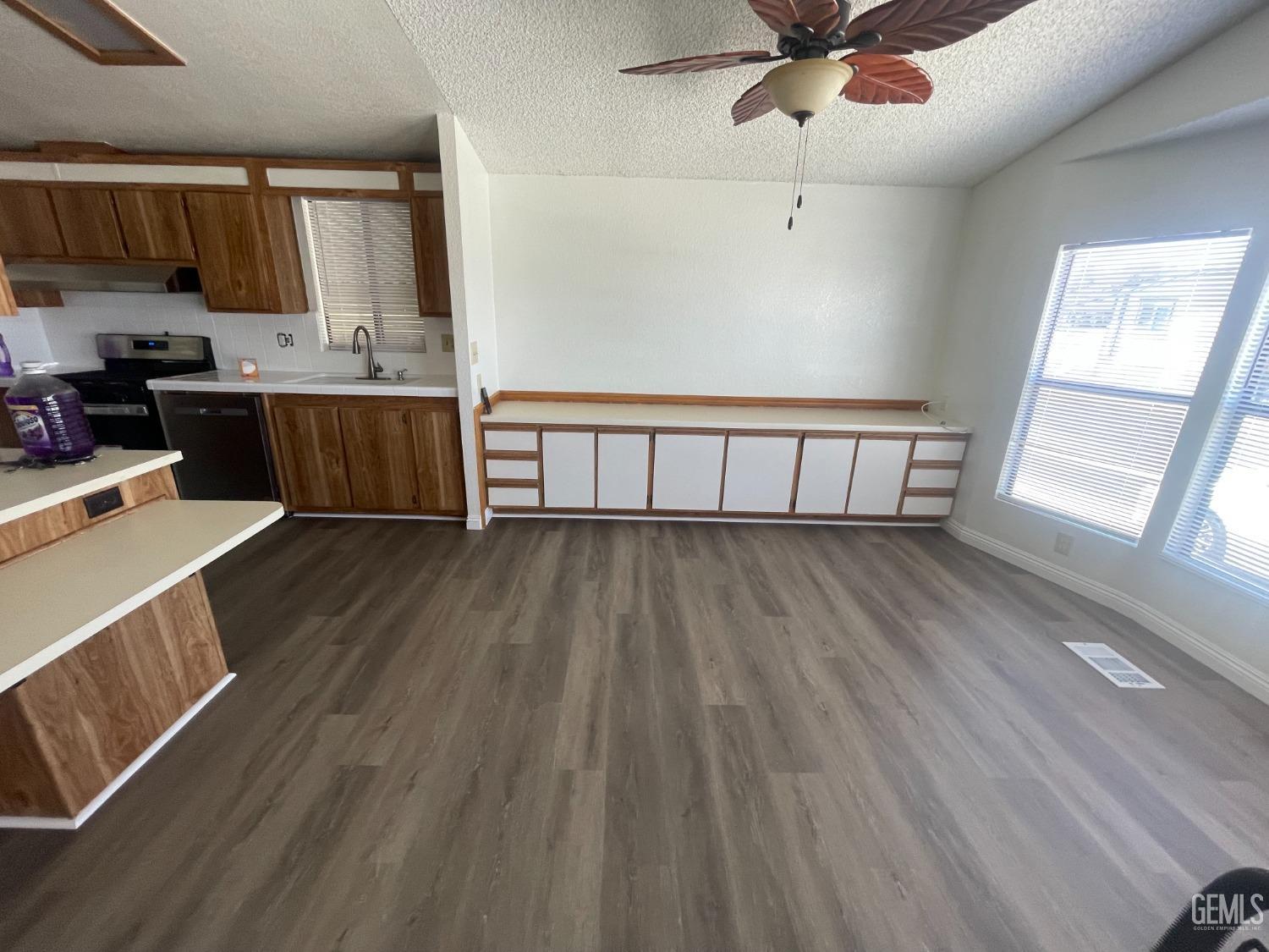 Undisclosed Address Bakersfield, CA 93307 - Photo 3 of 18 a view of kitchen with wooden floor and electronic appliances