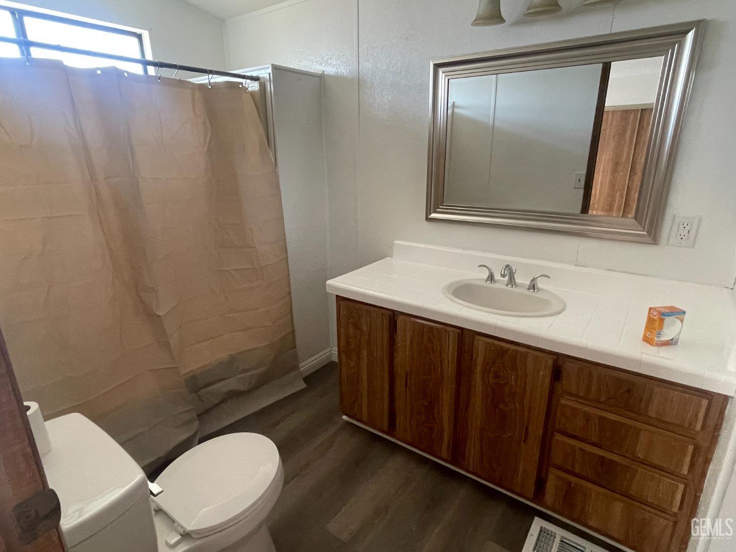 Undisclosed Address Bakersfield, CA 93307 - Photo 8 of 18 a bathroom with a sink vanity mirror and toilet