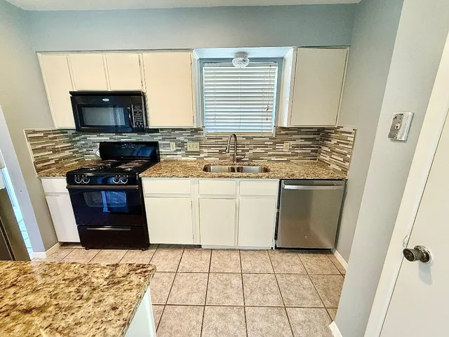 a kitchen with a stove top oven and cabinets