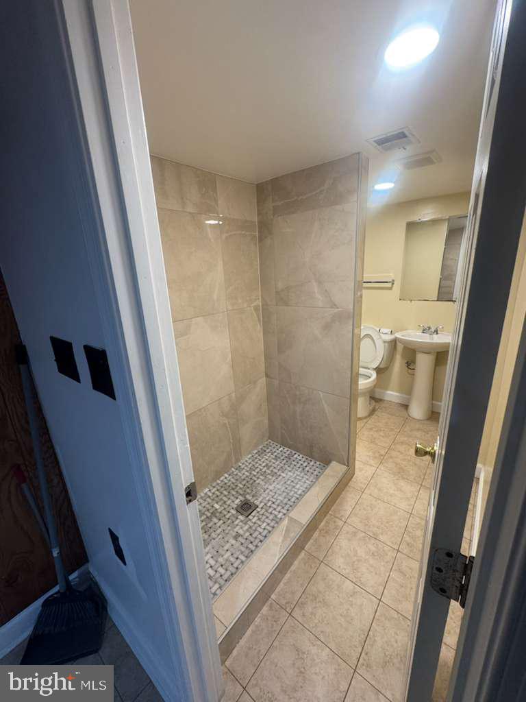 6112 Armor Drive Clinton, MD 20735 - Photo 11 of 15 a bathroom with a sink and a glass door shower