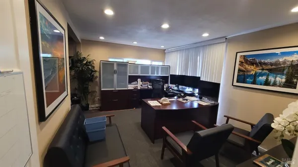 a view of a workspace with furniture and a window