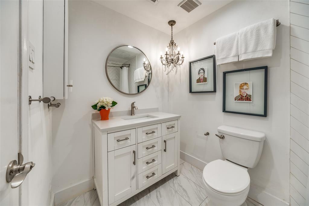 4034 Rawlins Street, Unit 104 Dallas, TX 75219 - Photo 14 of 19 a bathroom with a toilet a sink and mirror