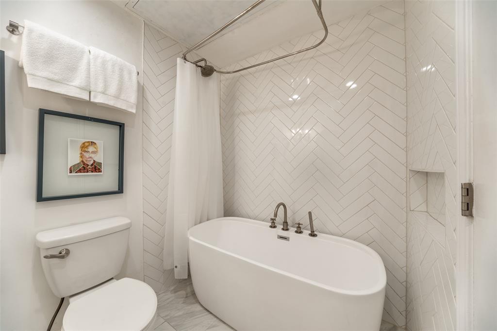 4034 Rawlins Street, Unit 104 Dallas, TX 75219 - Photo 15 of 19 a white toilet sitting next to a bathroom sink