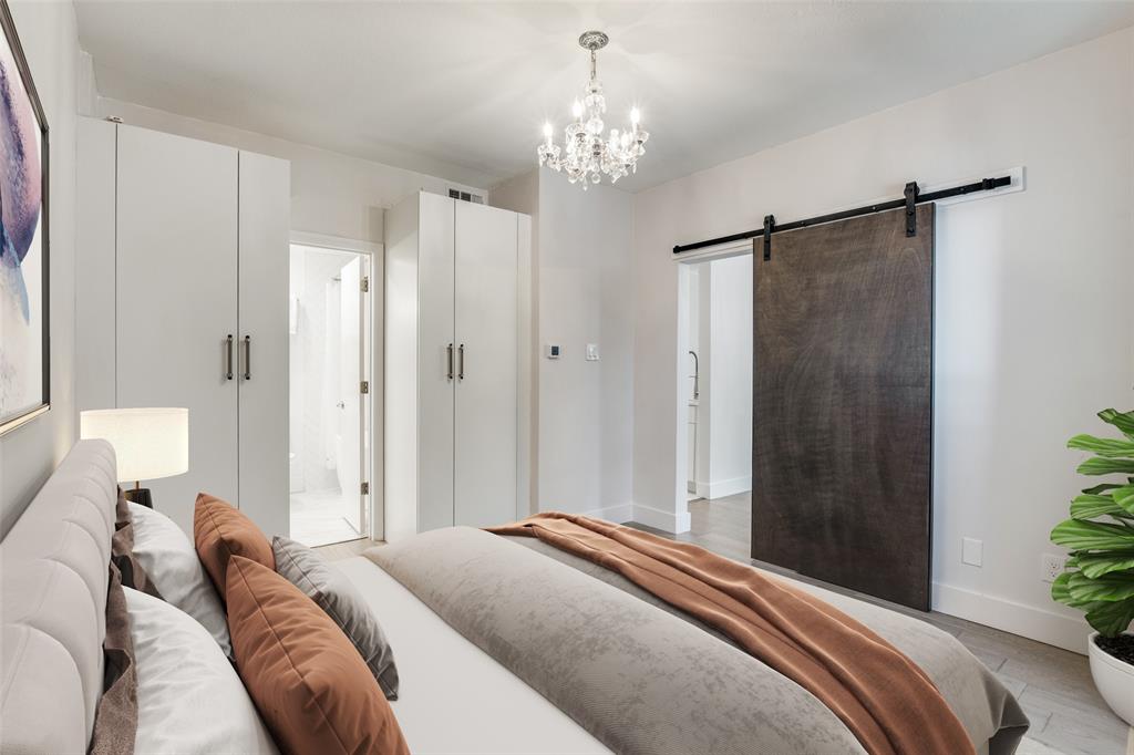 4034 Rawlins Street, Unit 104 Dallas, TX 75219 - Photo 4 of 19 a bedroom with a bed and a chandelier