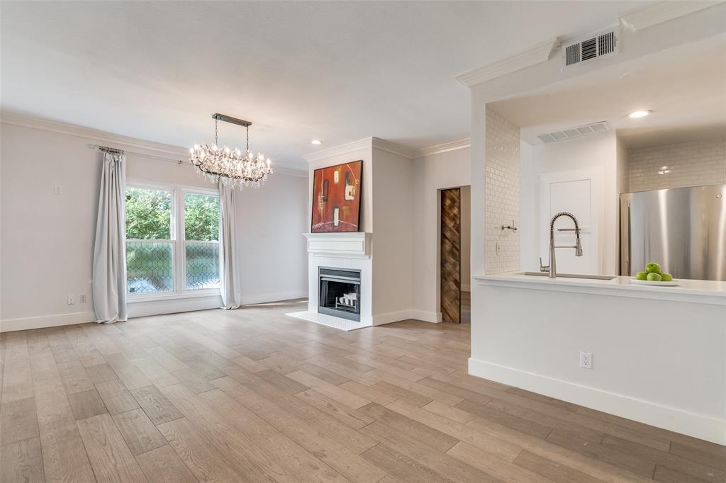 4034 Rawlins Street, Unit 104 Dallas, TX 75219 - Photo 6 of 19 a view of empty room with wooden floor and fireplace