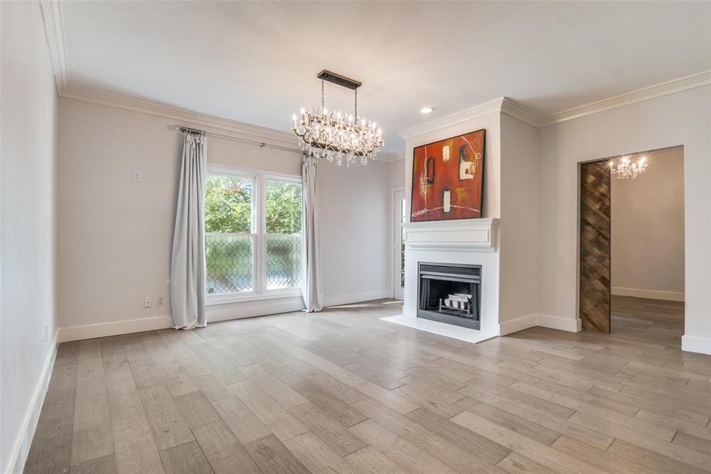4034 Rawlins Street, Unit 104 Dallas, TX 75219 - Photo 7 of 19 a view of a livingroom with a fireplace chandelier and windows
