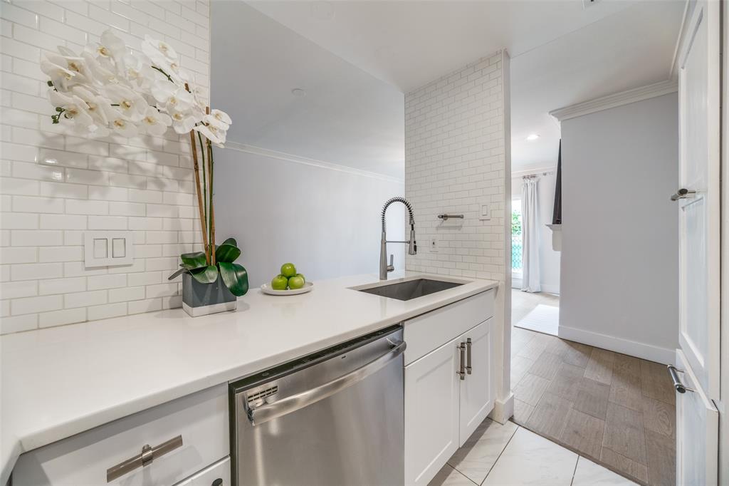 4034 Rawlins Street, Unit 104 Dallas, TX 75219 - Photo 9 of 19 a kitchen with a sink a potted plant and cabinets