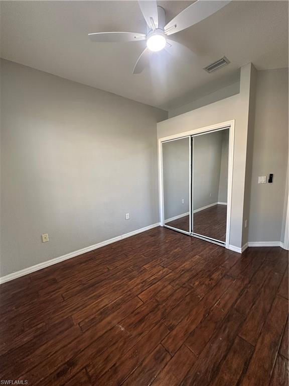 7350 Bristol Circle Naples, FL 34120 - Photo 8 of 14 Unfurnished bedroom with a closet, dark wood-type flooring, and a ceiling fan