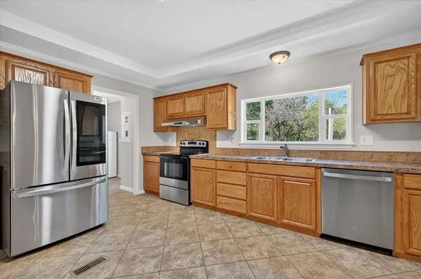 a kitchen with stainless steel appliances granite countertop a refrigerator sink and stove