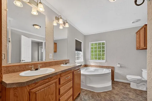 a bathroom with a sink double vanity granite and a toilet