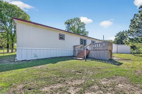 a view of a backyard with a house and wooden fence