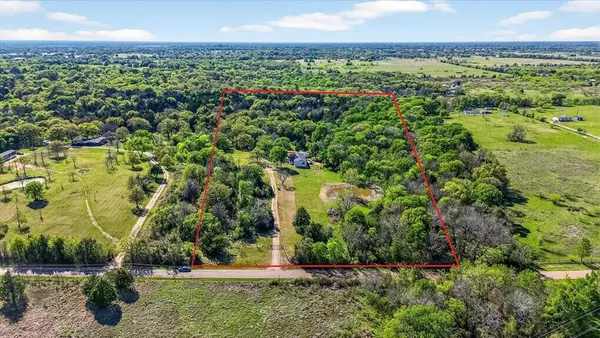 an aerial view of residential houses with outdoor space and trees