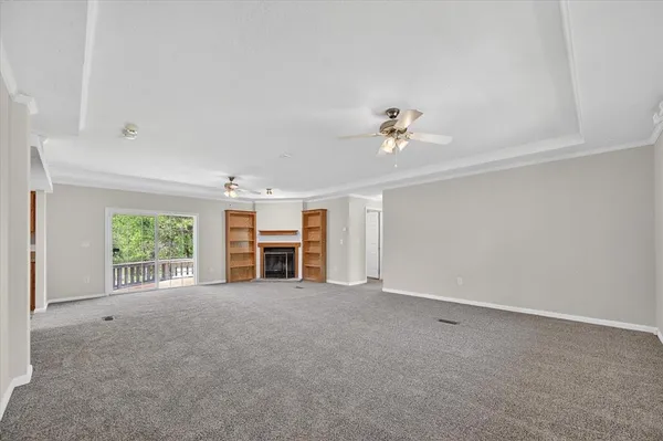 an empty room with windows and ceiling fan