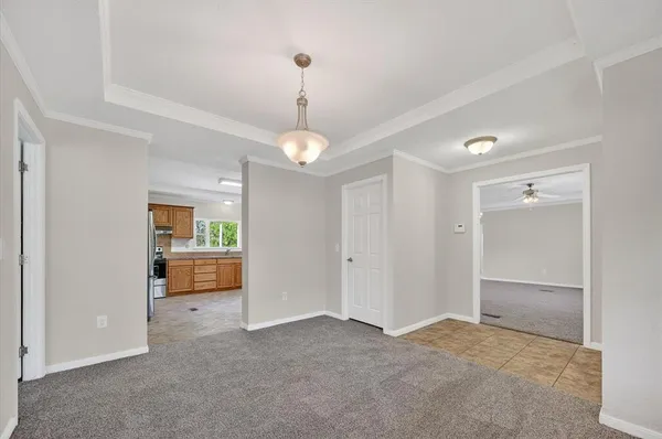 a view of an empty room and kitchen view