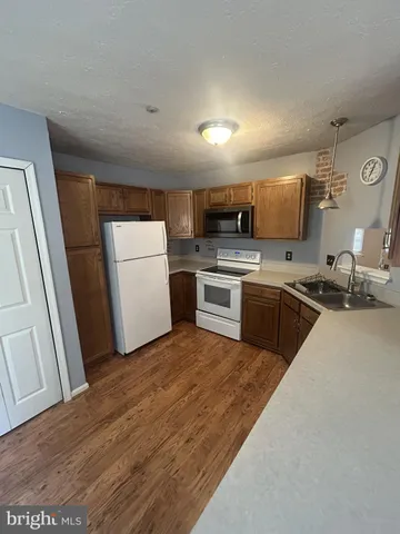 a kitchen with a sink a microwave a stove and refrigerator
