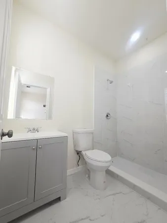 a bathroom with a sink a toilet and shower