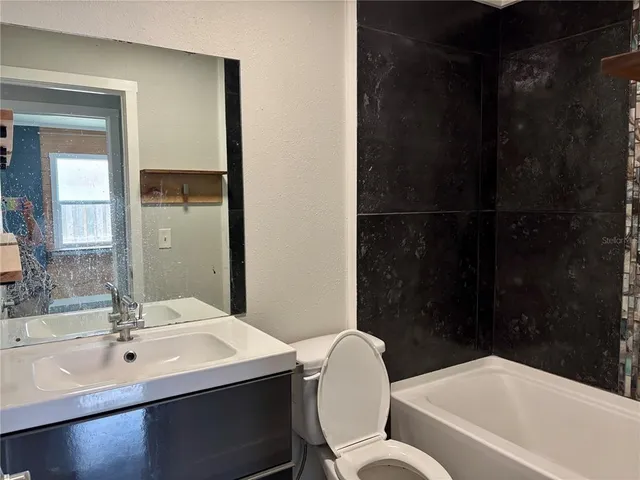a bathroom with a sink vanity mirror and toilet