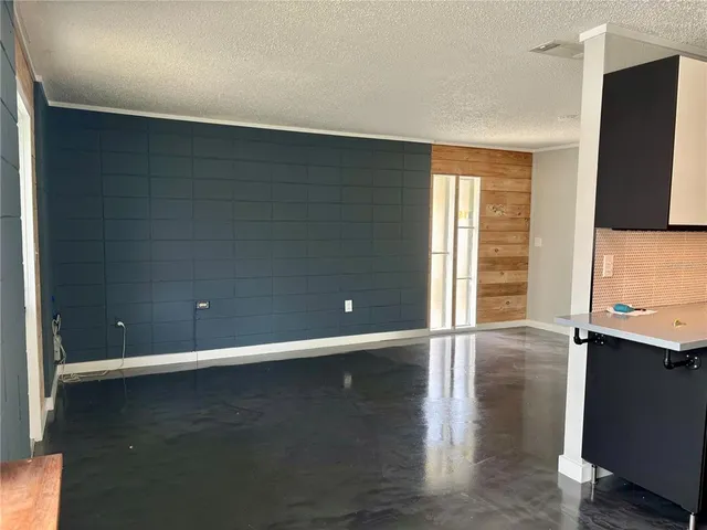 a view of a livingroom with an empty space and a window