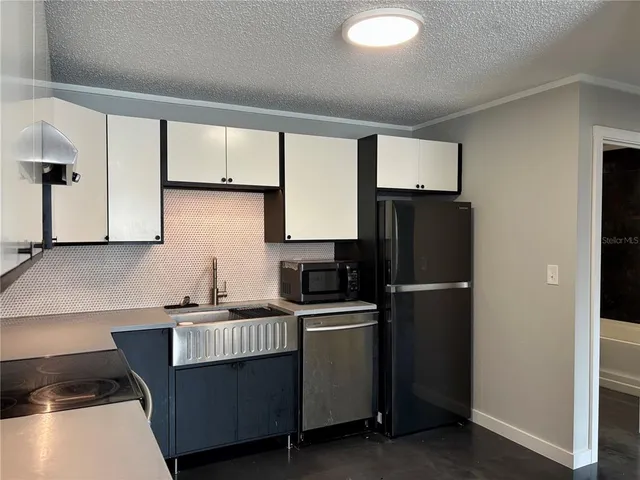 a kitchen with a sink a refrigerator and cabinets