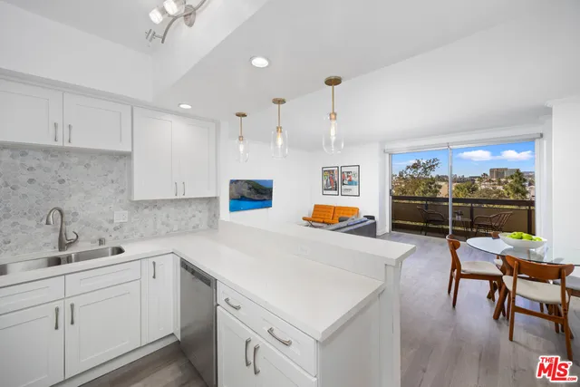 a kitchen that has a sink and chairs in it