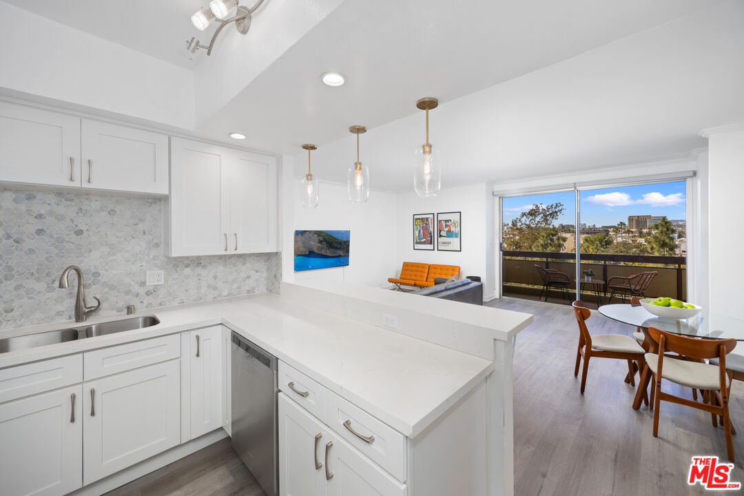 321 South San Vicente Boulevard, Unit 708 Los Angeles, CA 90048 - Photo 4 of 19 a kitchen that has a sink and chairs in it