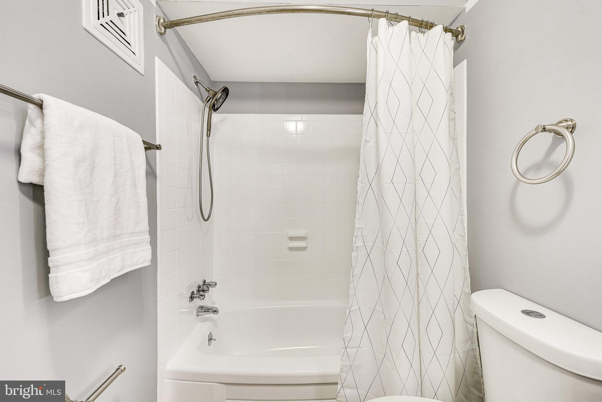 5909 B Prince James Drive, Unit B Springfield, VA 22152 - Photo 16 of 18 a bathroom with a shower curtain and a toilet