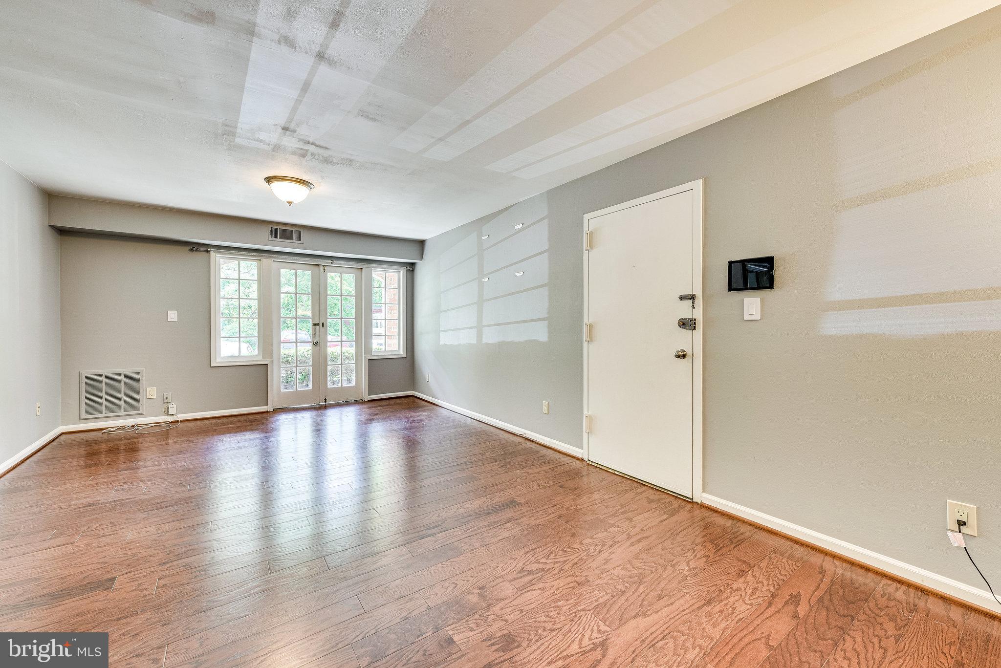 5909 B Prince James Drive, Unit B Springfield, VA 22152 - Photo 7 of 18 an empty room with wooden floor and windows