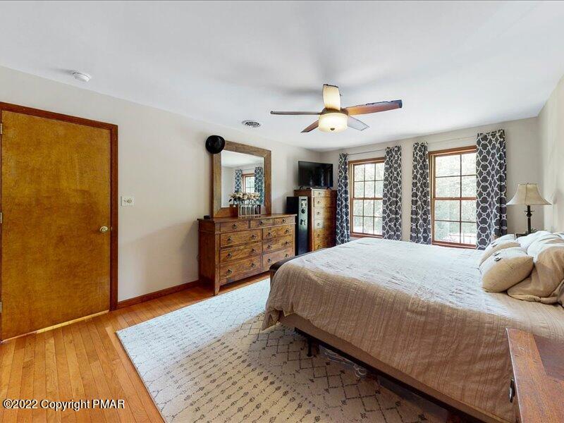 1080 Hampstead Road Bushkill, PA 18324 - Photo 24 of 62 a bedroom with a large bed and a chandelier