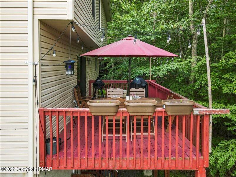1080 Hampstead Road Bushkill, PA 18324 - Photo 42 of 62 a roof deck with a yard a table and chairs under an umbrella