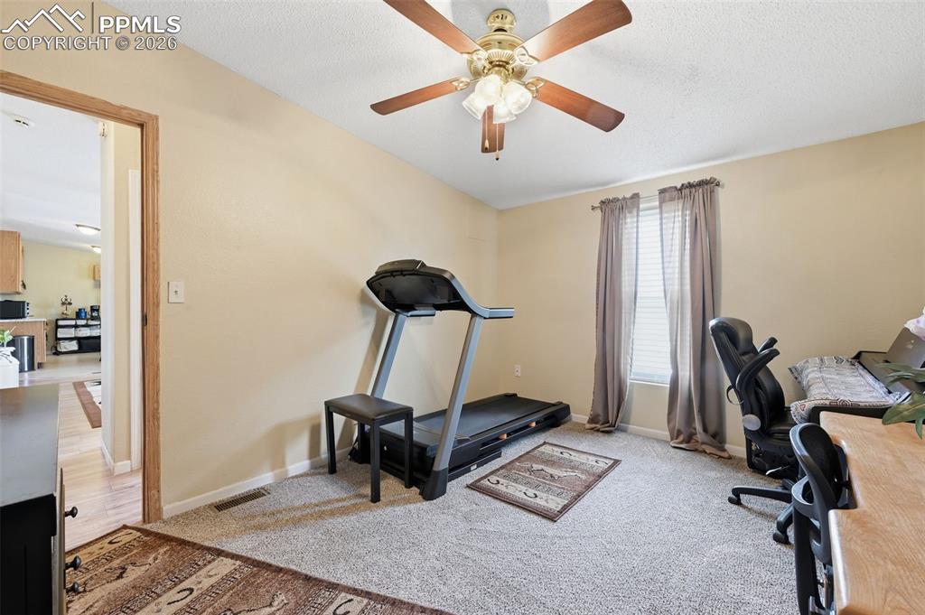 20985 McDaniels Road Calhan, CO 80808 - Photo 38 of 41 a room with gym equipment and a view of living room