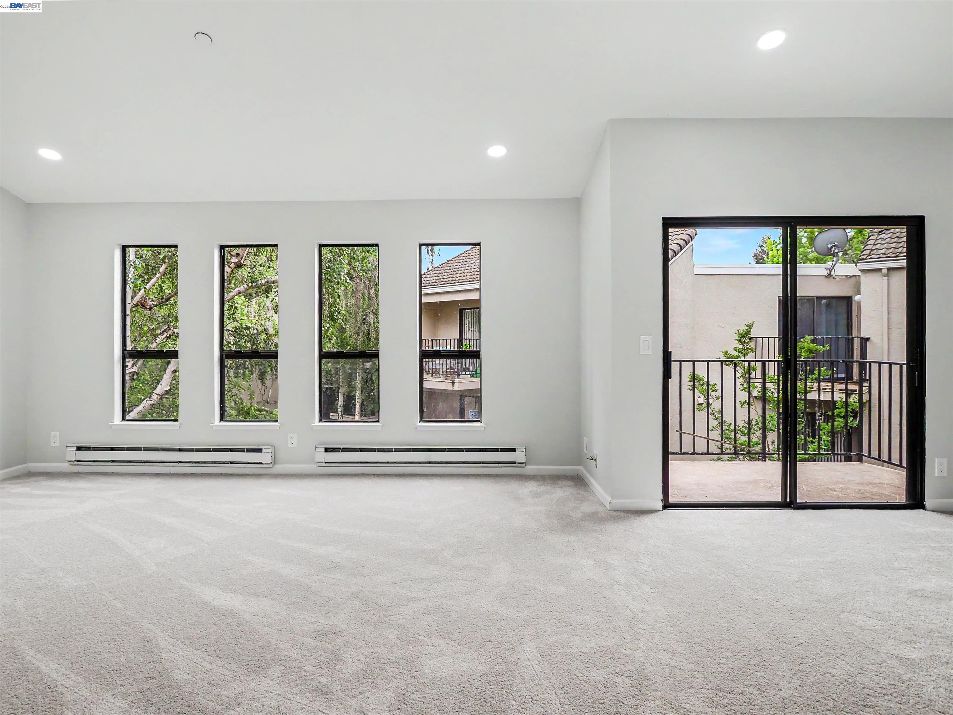 39450 Albany Common, Unit X Fremont, CA 94538 - Photo 19 of 46 a view of an empty room with a fireplace and large windows